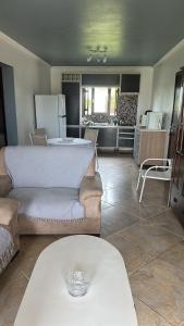 a living room with two couches and a kitchen at Casa do Igra in Torres