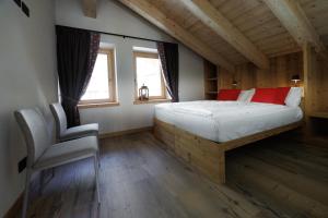 a bedroom with a bed and a chair in it at Chalet Boscopiano in Valdidentro
