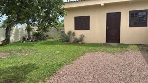 a house with a black door and a yard at Casa do Igra in Torres