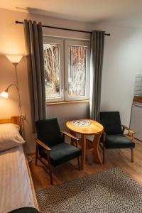 a room with a table and two chairs and a bed at Domki nad potokiem in Susiec