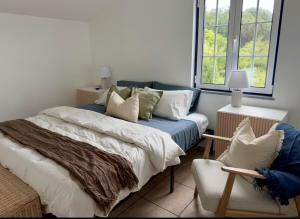 a bedroom with a bed with pillows and a chair at Island View Retreat in Feteira