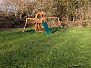 a playground with a slide in the grass at The Roost at The Gables Farm in Poynton