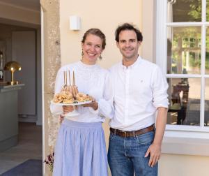 a man and a woman holding a plate of food at Hazelnut House - Luxembourg's Secret Small Hotel in Girsterklaus