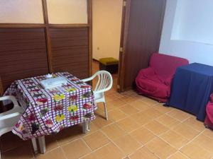 a small room with a table and a red couch at Triple B in Loja