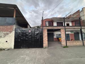 a building with a garage with a black gate at Triple B in Loja