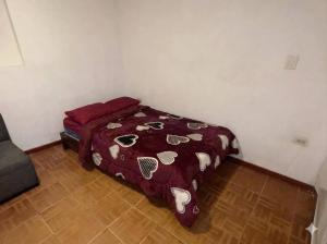 a bedroom with a bed with a red comforter at Triple B in Loja