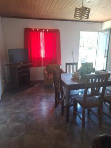 a living room with a table and a red curtain at Cabañas Cosquín in Cosquín