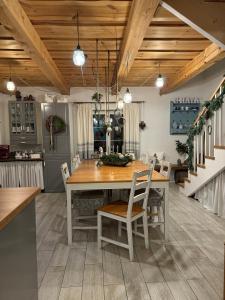 a kitchen and dining room with a wooden table and chairs at Chata na Zielonym Wzgórzu in Garcz