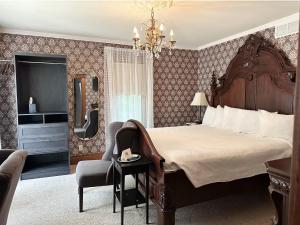 a bedroom with a large bed and a chair and a mirror at The Ginkgo Tree in Mount Pleasant