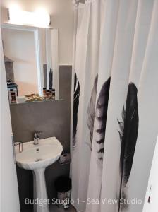 a bathroom with a sink and a shower curtain at Budget Studios Haraki in Haraki