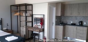 a room with a bed and a kitchen with a counter at Budget Studios Haraki in Haraki