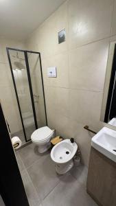 a bathroom with two toilets and a shower and a sink at Hotel Manquehue in Esquel