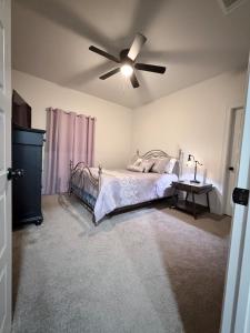 a bedroom with a bed and a ceiling fan at Wanderlust House in Shreveport