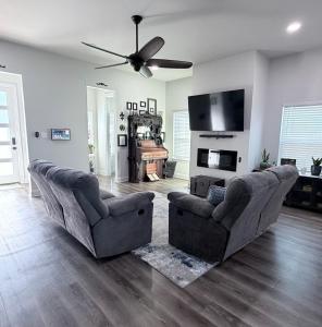 a living room with two couches and a flat screen tv at Wanderlust House in Shreveport