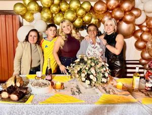 a group of women standing around a table with a cake at CABAÑA LOS NOGALES in San Agustín