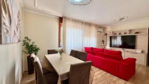 a living room with a red couch and a table at 3D apartment, central - prox UFN in Santa Maria