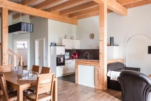 a kitchen and living room with a table and a dining room at Gut-Royum-Strohlager in Brodersby