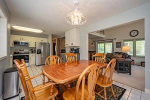 a kitchen and dining room with a wooden table and chairs at Cabin & Canoe by Railey Vacations in McHenry