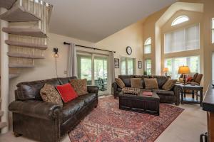 a living room with a leather couch and a table at Cabin & Canoe by Railey Vacations in McHenry
