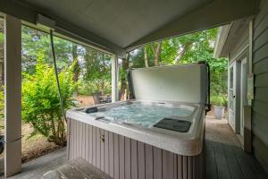 a hot tub on a screened in porch at Cabin & Canoe by Railey Vacations in McHenry