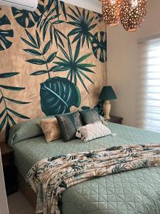 a bedroom with a green bed with a wall at Casa Familiar en La Paz BCS in La Paz