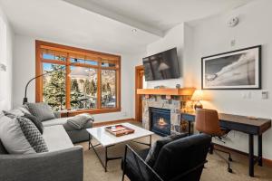 a living room with a couch and a fireplace at The Powder Post Capitol Peak Lodge #3225 in Snowmass Village