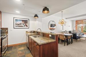 a kitchen with a sink and a living room at The Powder Post Capitol Peak Lodge #3225 in Snowmass Village +20 photos