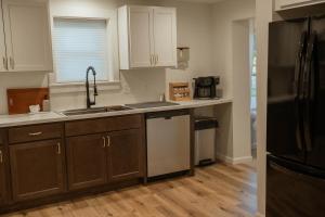 a kitchen with white cabinets and a black refrigerator at The Ginkgo Tree in Mount Pleasant