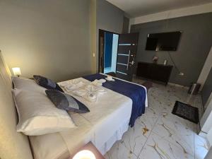 a hotel room with a large bed with a television at Hotel Kiara in Cataltzul +10 photos