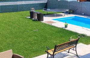 a bench sitting next to a yard with a swimming pool at Gemütliche Unterkunft in Pottendorf in Pottendorf