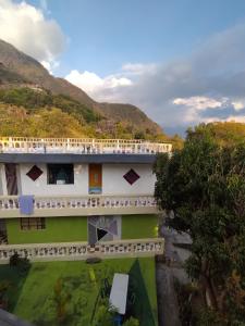 an aerial view of a building with mountains in the background at Nawal Hostel in Santa Cruz La Laguna