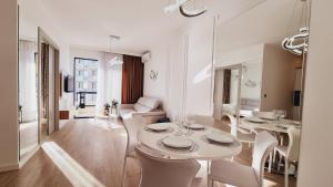 a dining room with white tables and white chairs at CASA AL MARE by Moskva in Budva