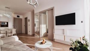 a living room with a couch and a tv on a wall at CASA AL MARE by Moskva in Budva