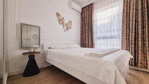 a white bedroom with a bed and a window at CASA AL MARE by Moskva in Budva +63 photos
