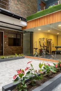 a house with glass walls and a patio with flowers at Hotel Santiago de Compostella Suites in Cuenca