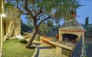 a hammock in a backyard with a tree and a fireplace at House Niksi in Škrip