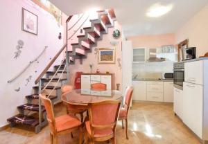 a kitchen and dining room with a table and a spiral staircase at House Niksi in Škrip