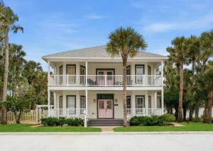 a large white house with palm trees at Be A Nomad - Pool Access Studio Apartment - Jacksonville Beach Couples in Jacksonville Beach