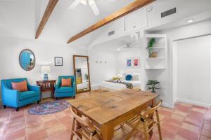 a living room with a wooden table and blue chairs at Be A Nomad - Pool Access Studio Apartment - Jacksonville Beach Couples in Jacksonville Beach +8 photos