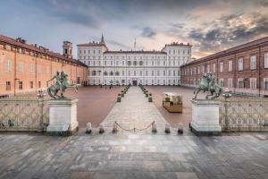 a large building with two statues in front of it at Castello Living in Turin