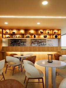 a restaurant with tables and chairs and a kitchen at Hotel Santiago de Compostella Suites in Cuenca