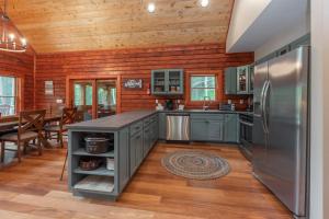 a kitchen with a stainless steel refrigerator and wooden walls at Lakefront Escape by Railey Vacations in Swanton