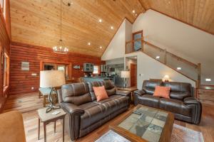 a living room with leather furniture and wooden walls at Lakefront Escape by Railey Vacations in Swanton