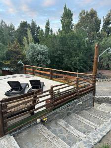 a wooden fence with two chairs on a patio at Altos del Cordón in Comodoro Rivadavia