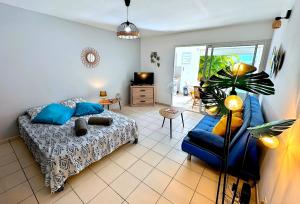 a living room with a bed and a blue couch at Ti Turtle in Saint-François +4 photos