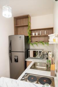 a kitchen with a stainless steel refrigerator and a sink at Loft Montecarlo in Hermosillo