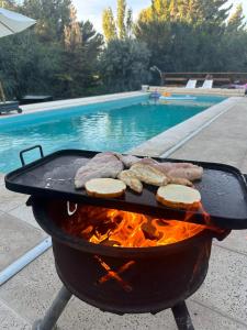 a grill with meat andurgers on it next to a pool at Altos del Cordón in Comodoro Rivadavia