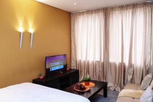 a hotel room with a bed and a television at The Orange Corner II in Johannesburg