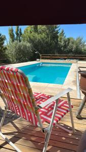 a red and white chair sitting next to a swimming pool at Altos del Cordón in Comodoro Rivadavia