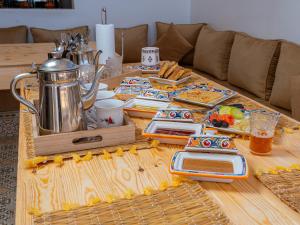 a wooden table with plates and utensils on it at Roots Surf House - Anza in Agadir